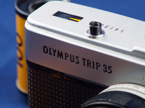 Free Close-up of an Olympus Trip 35 camera with film roll, highlighting the retro design and photography nostalgia. Stock Photo