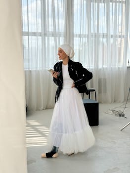Fashionable young woman with prosthetic leg checks her phone in a bright room.