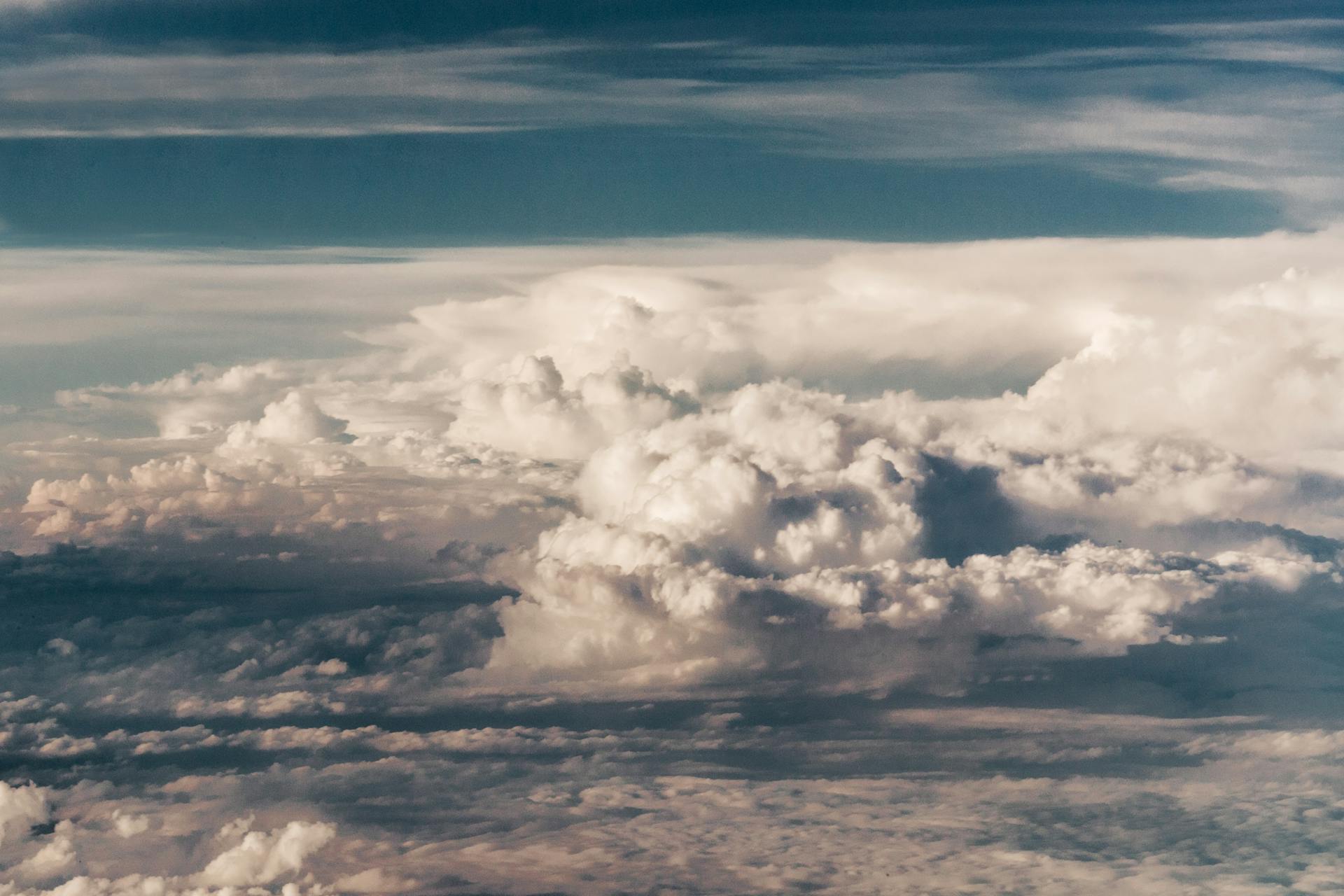 A breathtaking view of dramatic cumulonimbus clouds from above, capturing the essence of meteorology and flight.