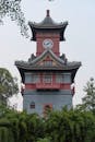 Traditional Chinese Clock Tower Amidst Greenery