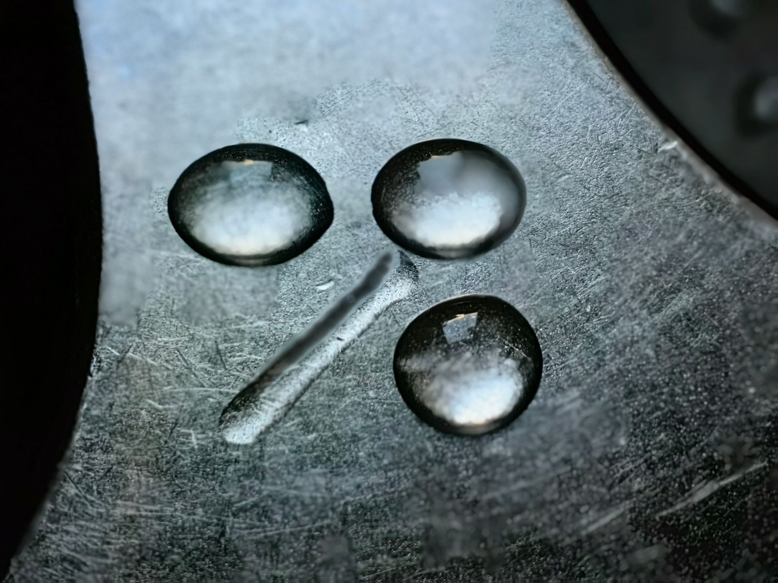 Water droplets on a reflective textured metal surface