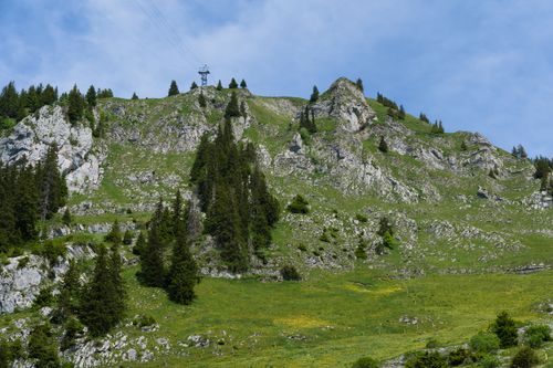 Free Beautiful alpine landscape featuring rocky peaks and lush green vegetation under a clear blue sky. Stock Photo