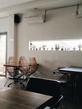 Modern cafe interior with wicker chairs and natural light in Malang, Indonesia.
