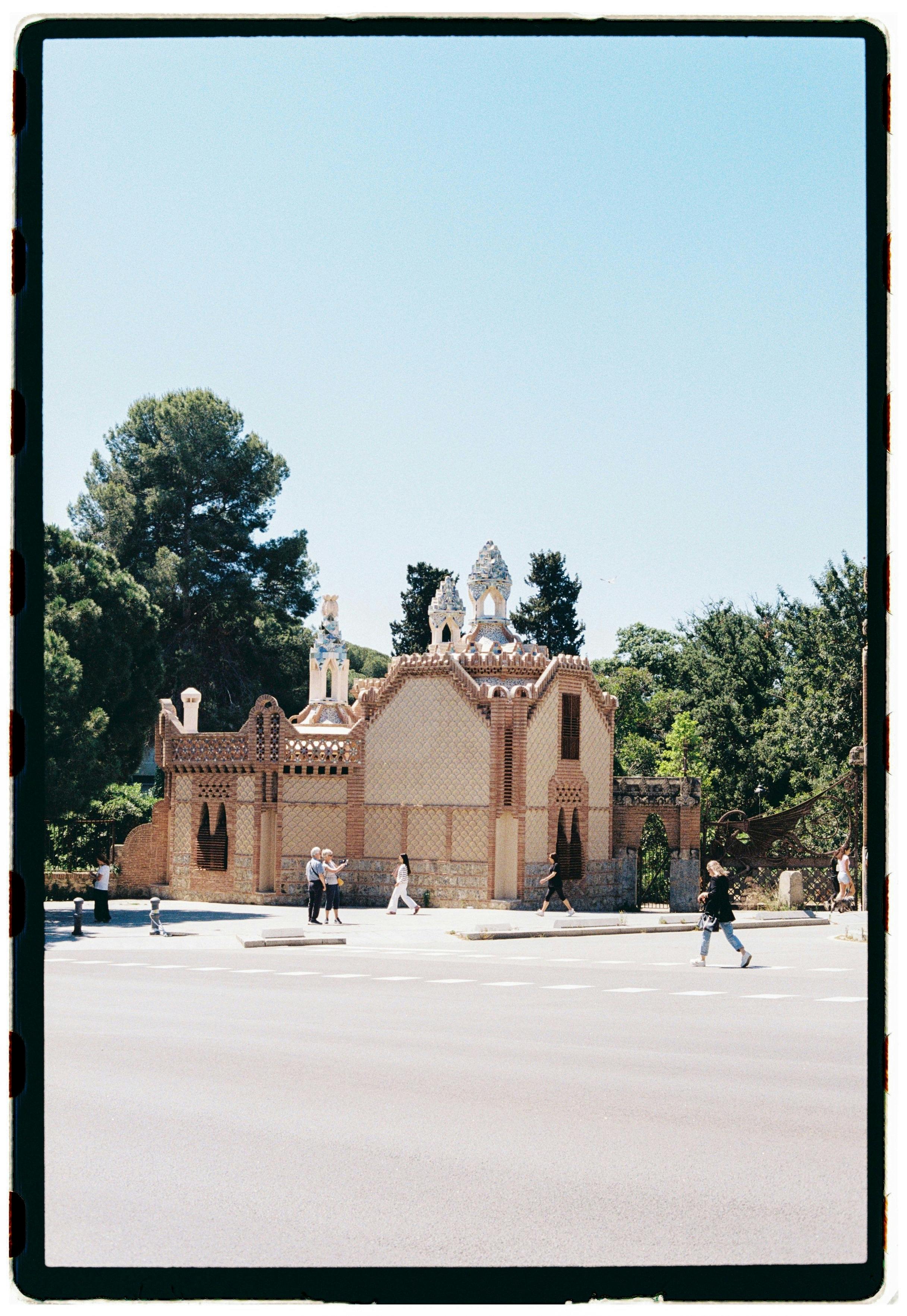 Vintage-style photo of a historic building with people walking by in Barcelona.