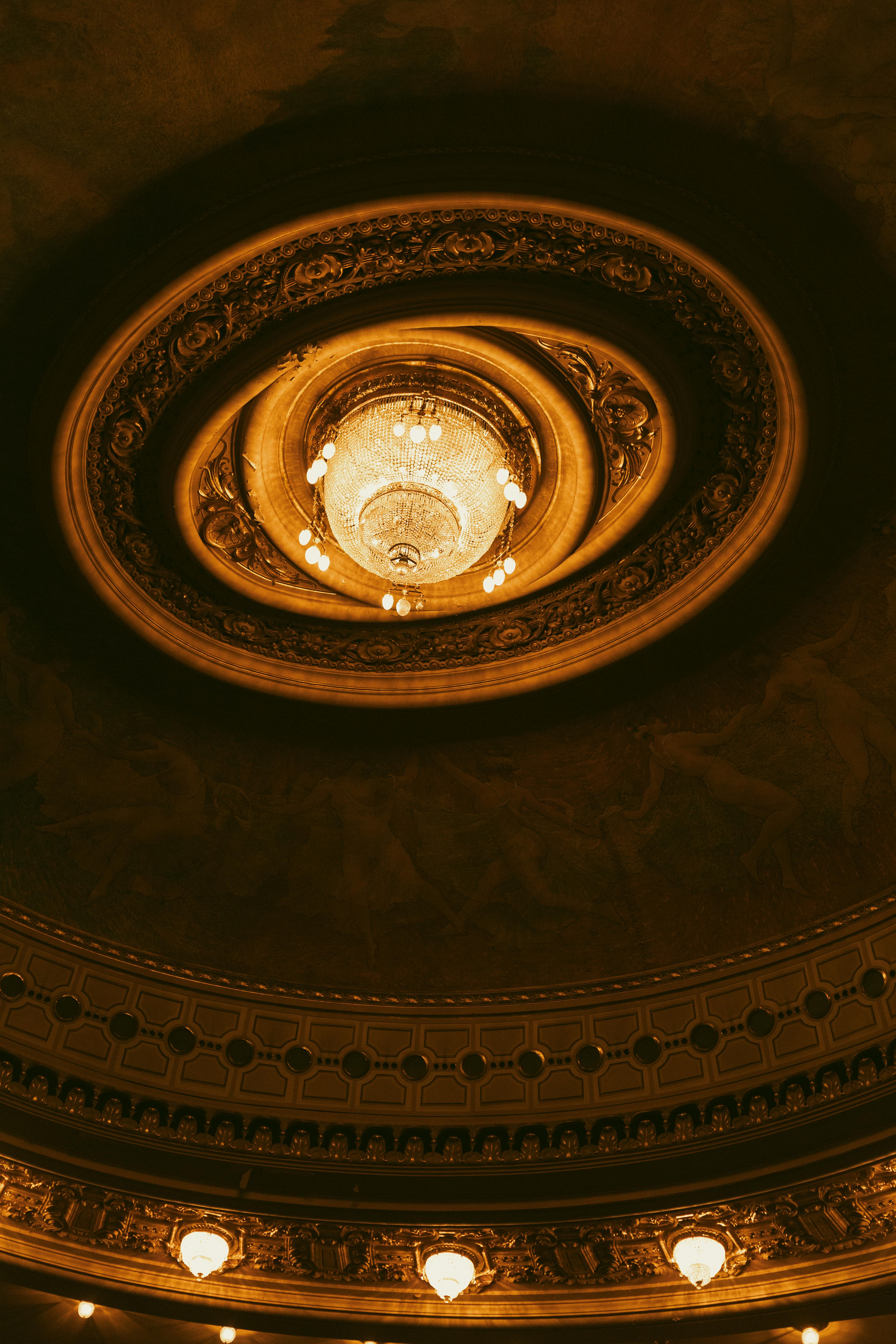 Bezpłatne Luksusowy sufit teatru ozdobiony ozdobnym żyrandolem, prezentujący klasyczny projekt architektoniczny. Zdjęcie z galerii