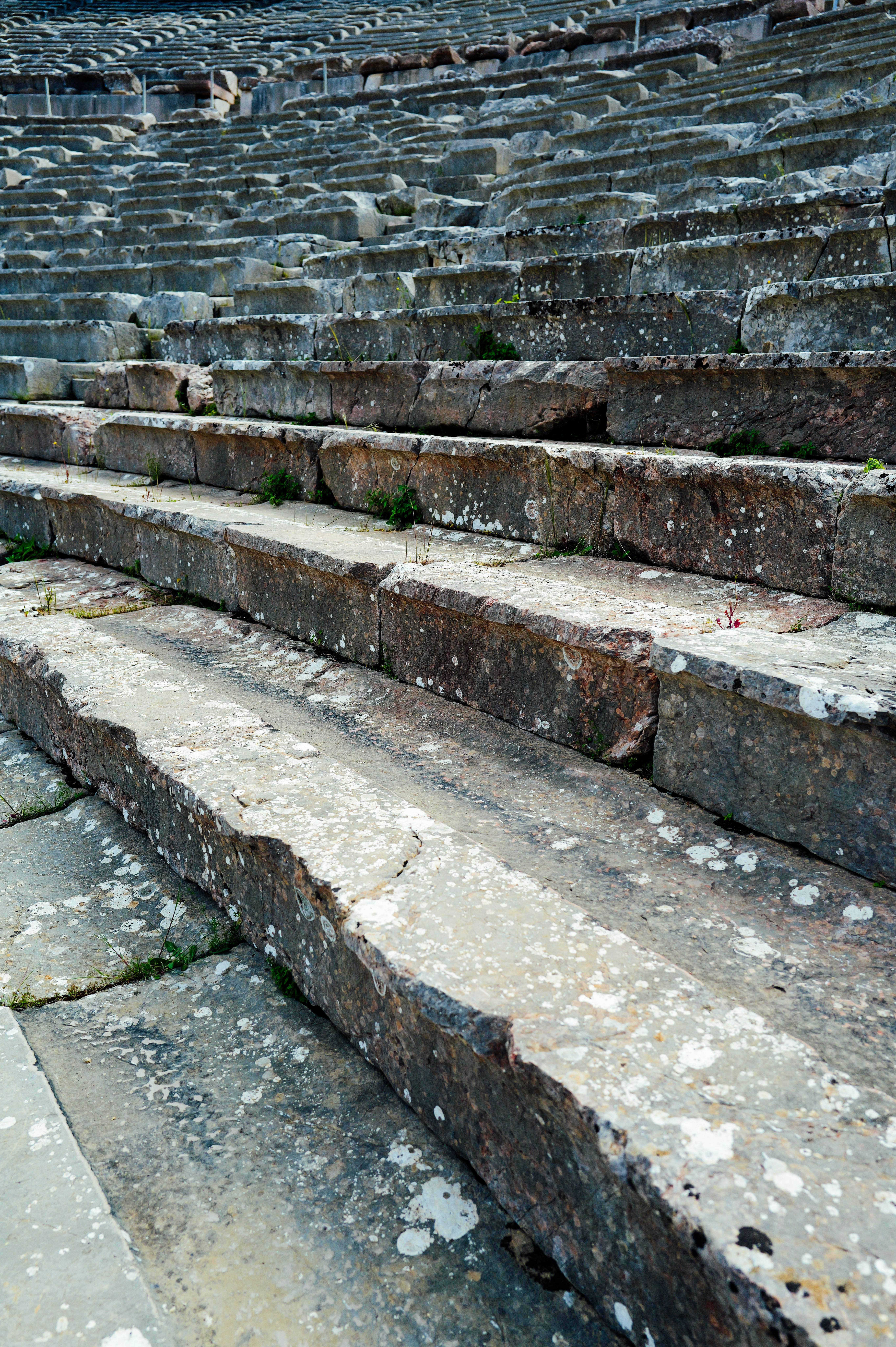 Ücretsiz Tarihi bir amfitiyatroda yıpranmış dokuları sergileyen antik taş basamakların detaylı görünümü. Stok Fotoğraflar