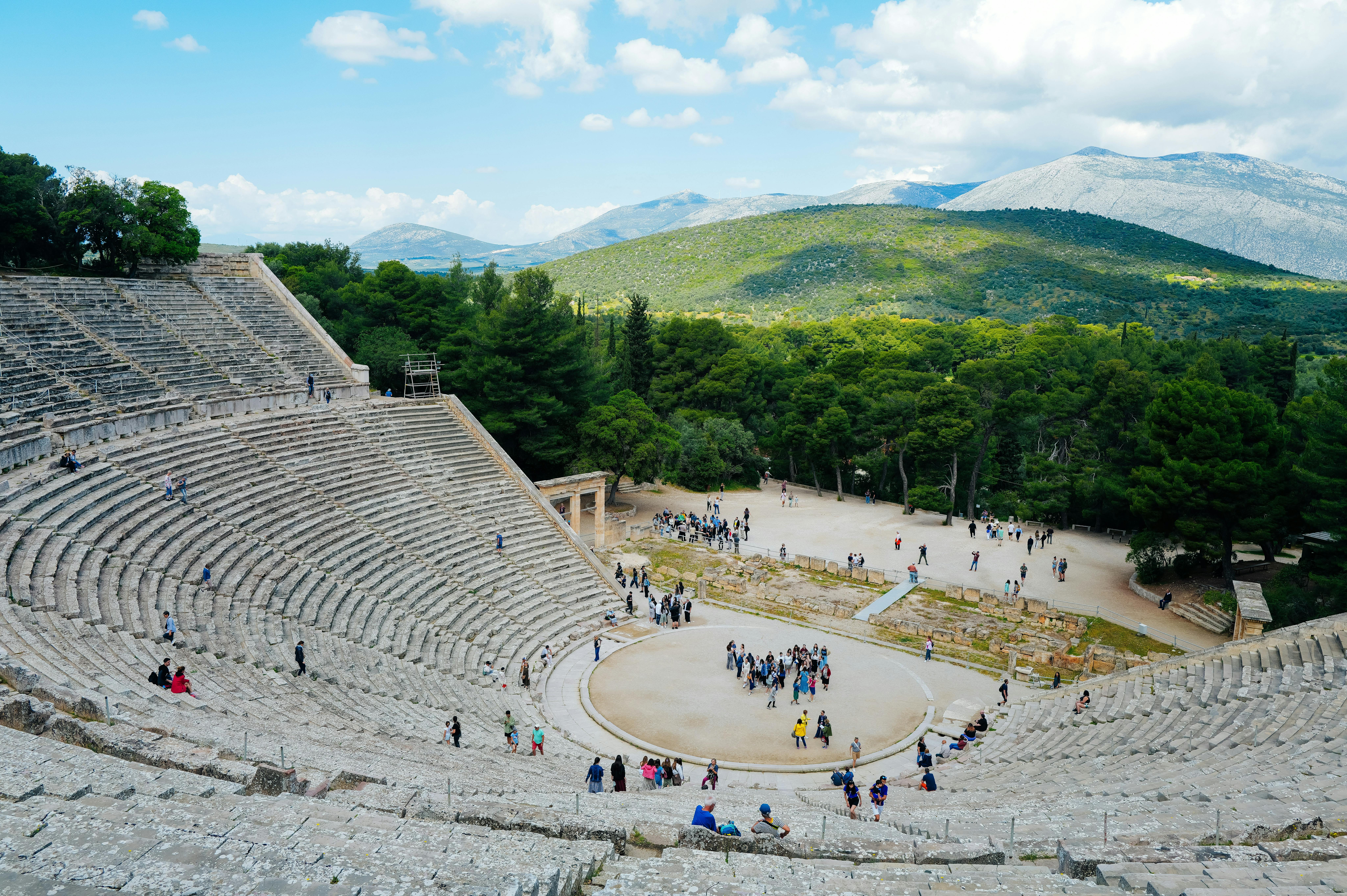 Gratuit Vue du théâtre antique d'Épidaure lors d'une journée ensoleillée, avec des touristes en train d'explorer. Photos