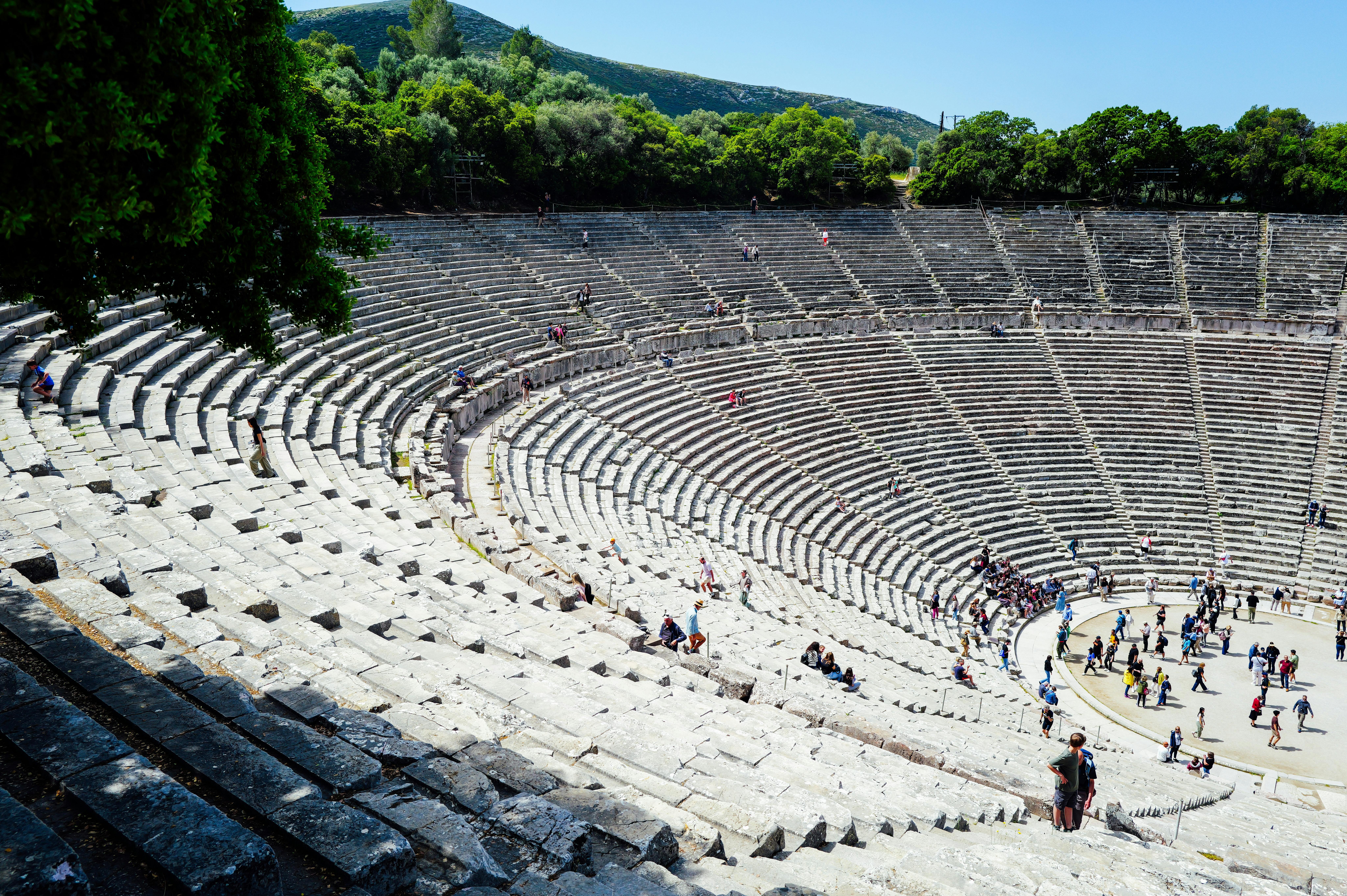 Miễn phí Ảnh chụp từ trên cao của đấu trường Epidaurus cổ đại được bao quanh bởi cây xanh với du khách đang khám phá địa điểm lịch sử này. Ảnh lưu trữ