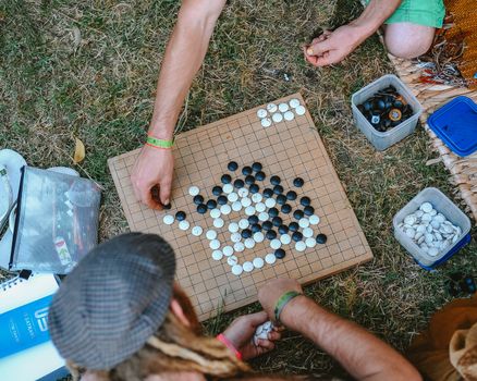 Aerial view of people playing Go outdoors, showcasing a casual game setup on a grassy lawn.