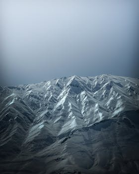 Majestic snow-capped mountains under a clear blue sky, capturing winter's essence.
