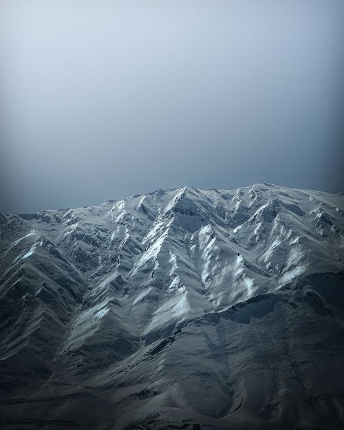 Free Majestic snow-capped mountains under a clear blue sky, capturing winter's essence. Stock Photo