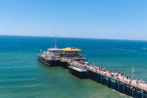 Free Scenic aerial view of Santa Monica Pier with vibrant blue ocean on a clear summer day. Stock Photo