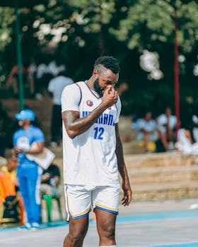 Basketball player wearing a white uniform on an outdoor court during a game.