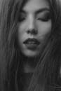 特写镜头单色肖像的一个女人长头发和眼睛关闭，创造一个宁静的表达