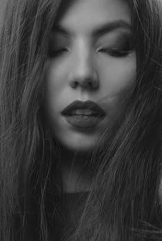 这是一幅特写单色肖像，画中一位长发女子闭着双眼，神情宁静