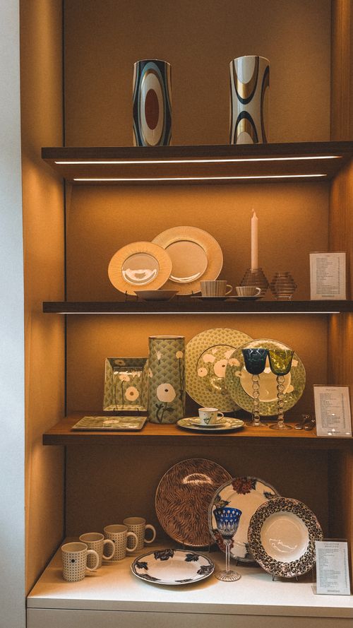 Free Elegant display of stylish crockery and decor in a warm-lit shelf setting. Stock Photo