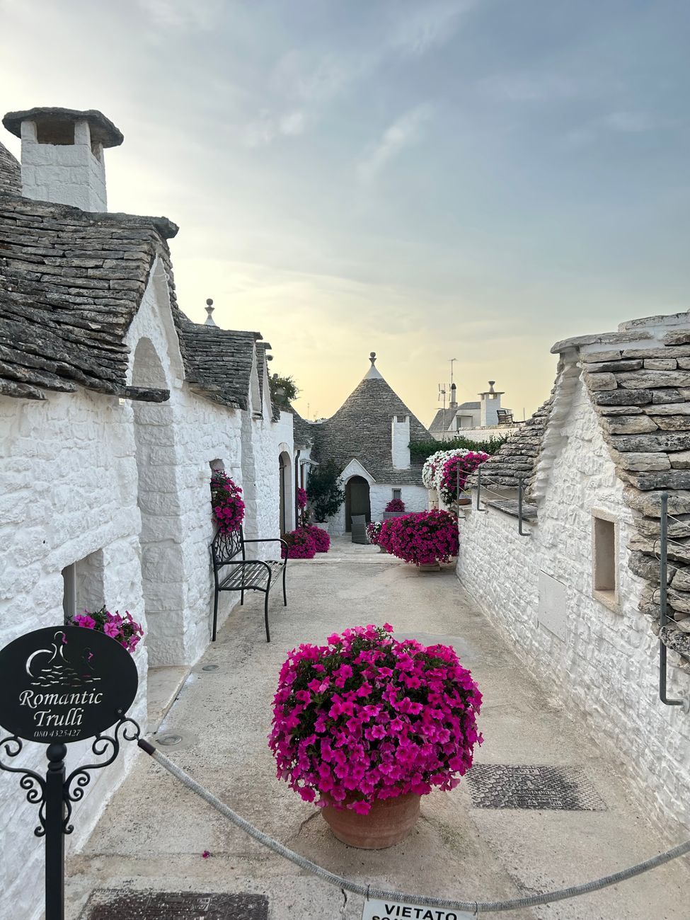 whitewashed alley with flowers in an Italian old town