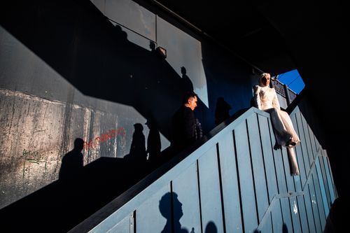 Free Bride sitting on stairs, casting shadows, in a geometric setting in Istanbul. Stock Photo
