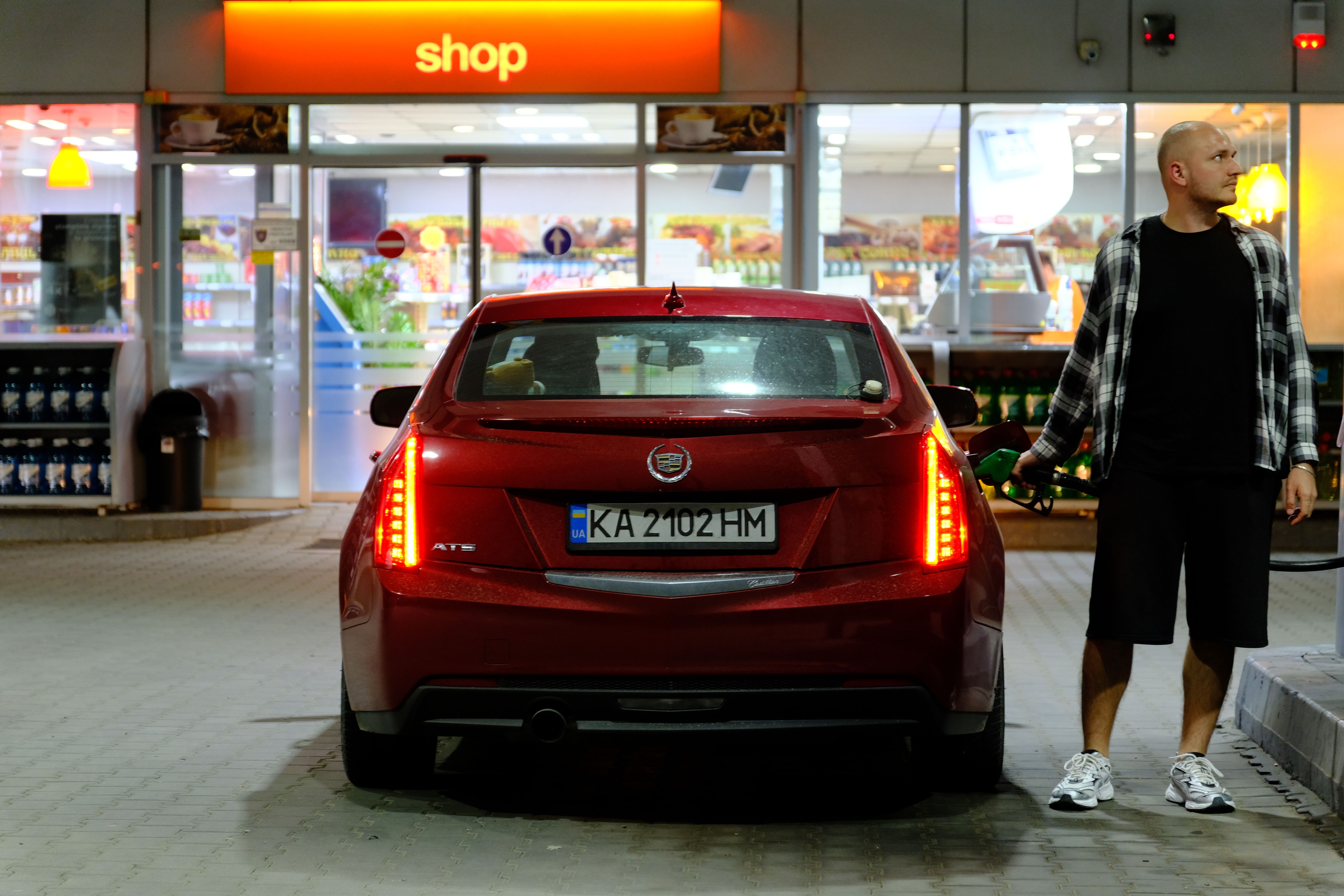 A man fueling a car at a gas station