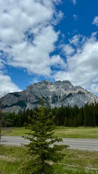 Majestic mountain view in Banff National Park, Canada, with blue skies and evergreen trees.