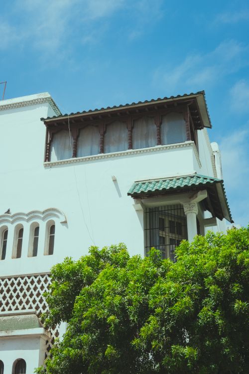 Free Beautiful Moroccan building in Rabat featuring traditional architectural elements and lush greenery. Stock Photo