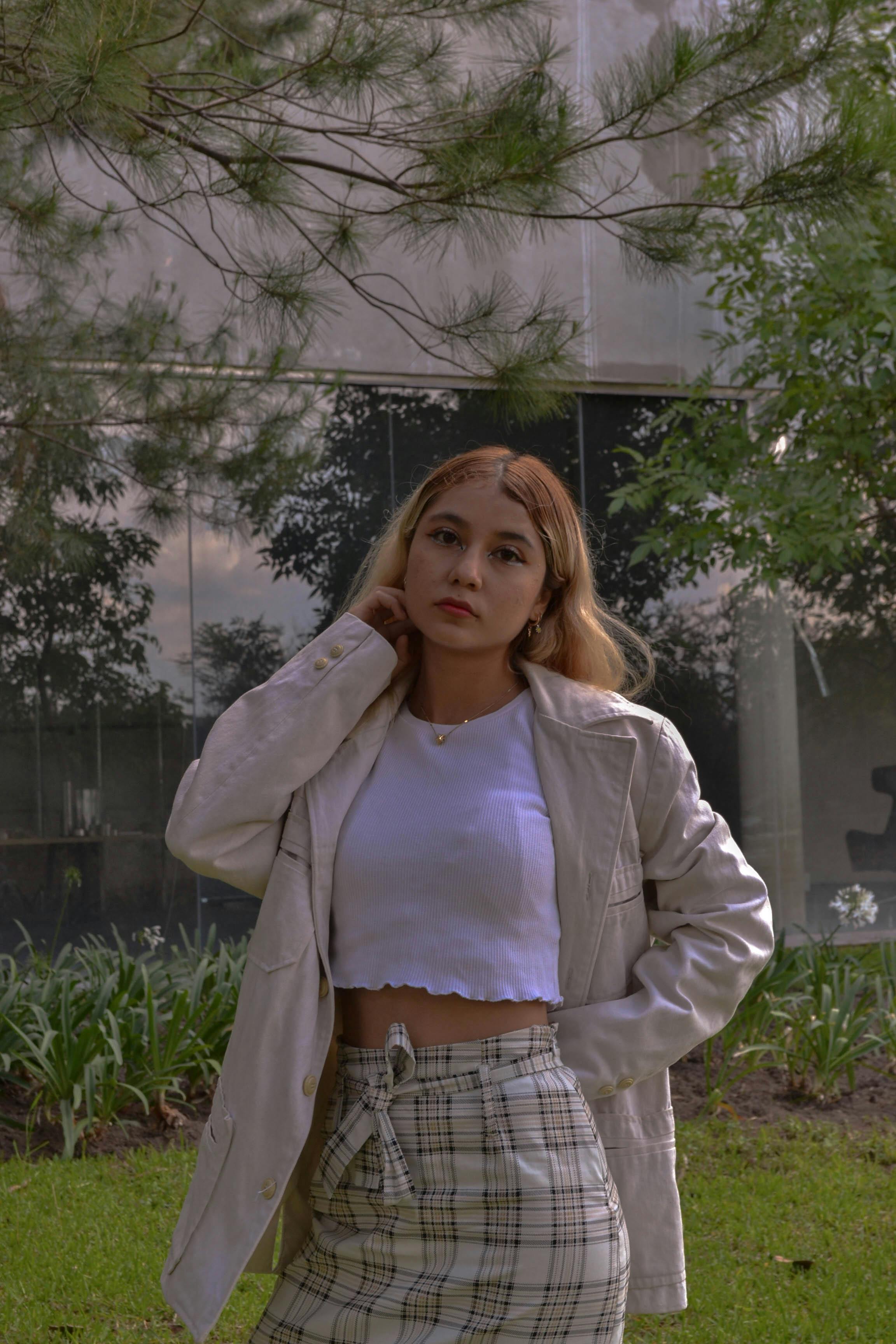 Free Portrait of a fashionable young woman posing outdoors in a natural setting. Stock Photo