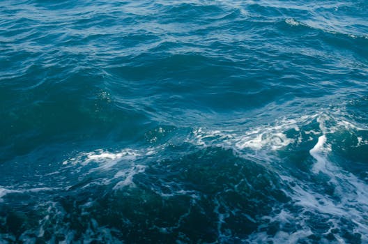 Tranquil view of aqua blue sea with gentle waves and sea foam.