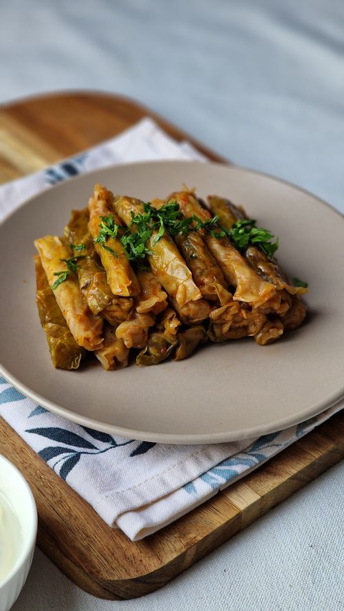 Free Delicious homemade stuffed cabbage rolls garnished with fresh herbs, served on a plate. Stock Photo