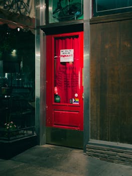 Closed red restaurant door in Fresno, CA at night with an open on Mondays sign.