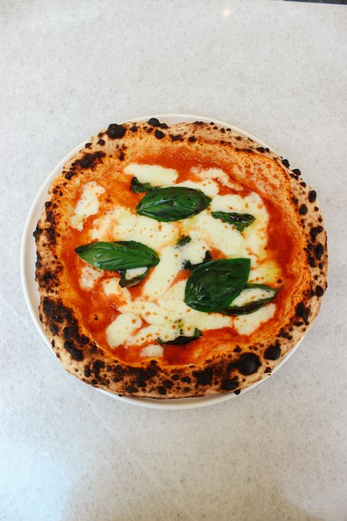 Free Top-down view of freshly baked Neapolitan Margherita pizza with basil and cheese. Stock Photo