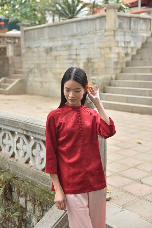 Free Elegant young woman in traditional red cheongsam posing outdoors with serene expression. Stock Photo