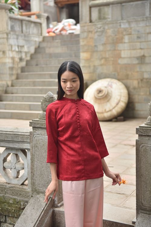 Free Elegant woman in red traditional clothing in an architectural courtyard. Stock Photo