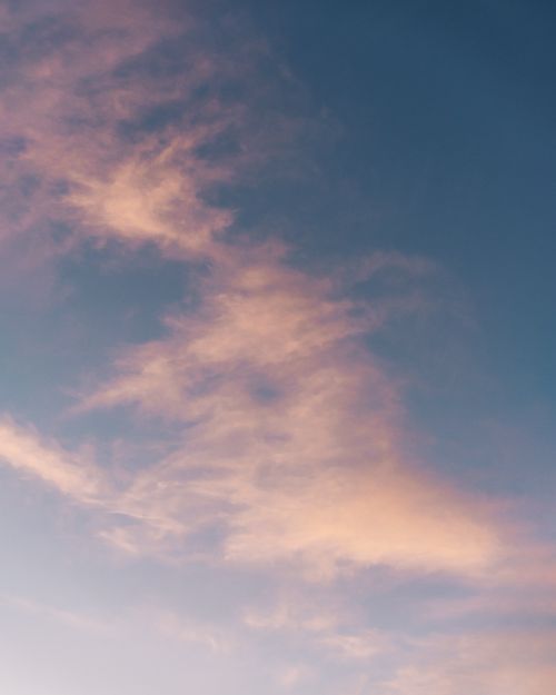 Free Gorgeous sunset showcasing soft pink clouds against a deep blue sky. Stock Photo