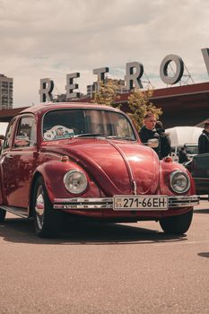 Classic red Volkswagen Beetle showcased at a retro car exhibition in Kyiv.