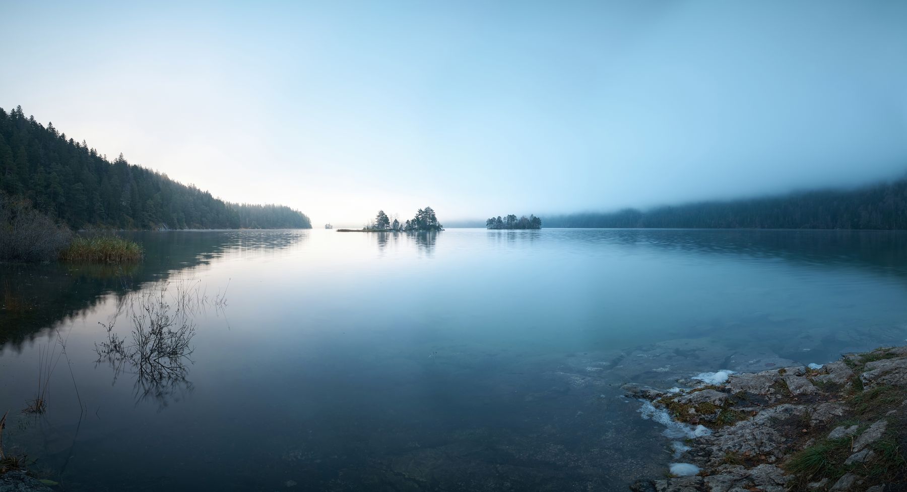 Still lake at first light with mist over the far treeline — photo by Tommes Frites on Pexels