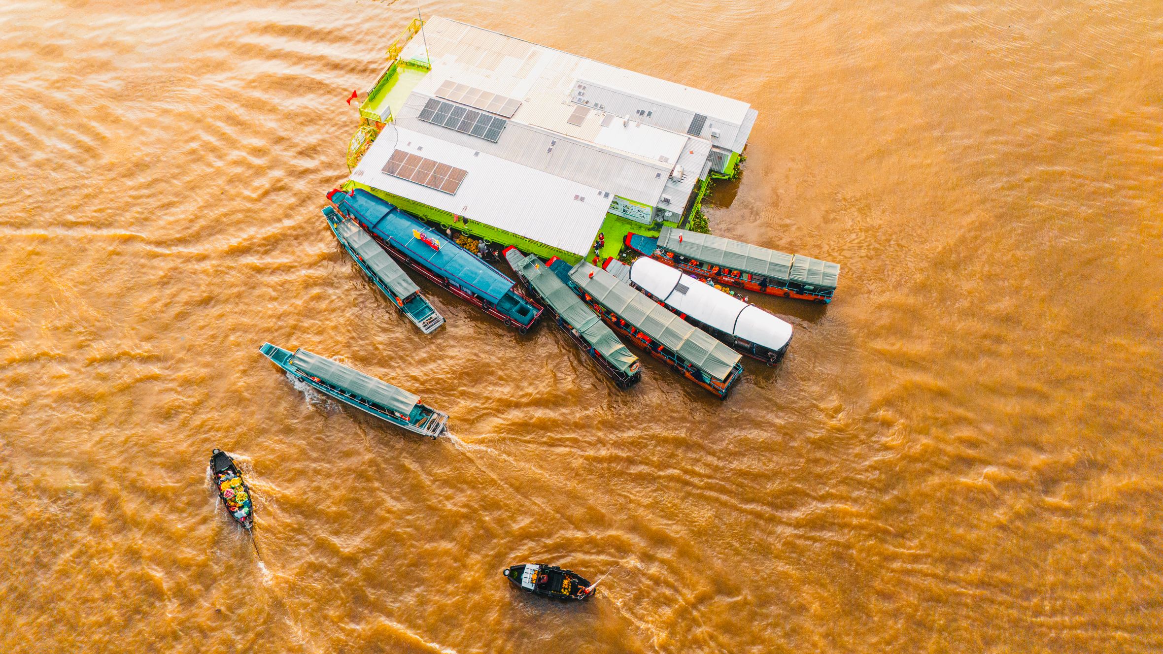 Vibrant scene of boats docked at Cái Răng Floating Market in Cần Thơ, Vietnam.