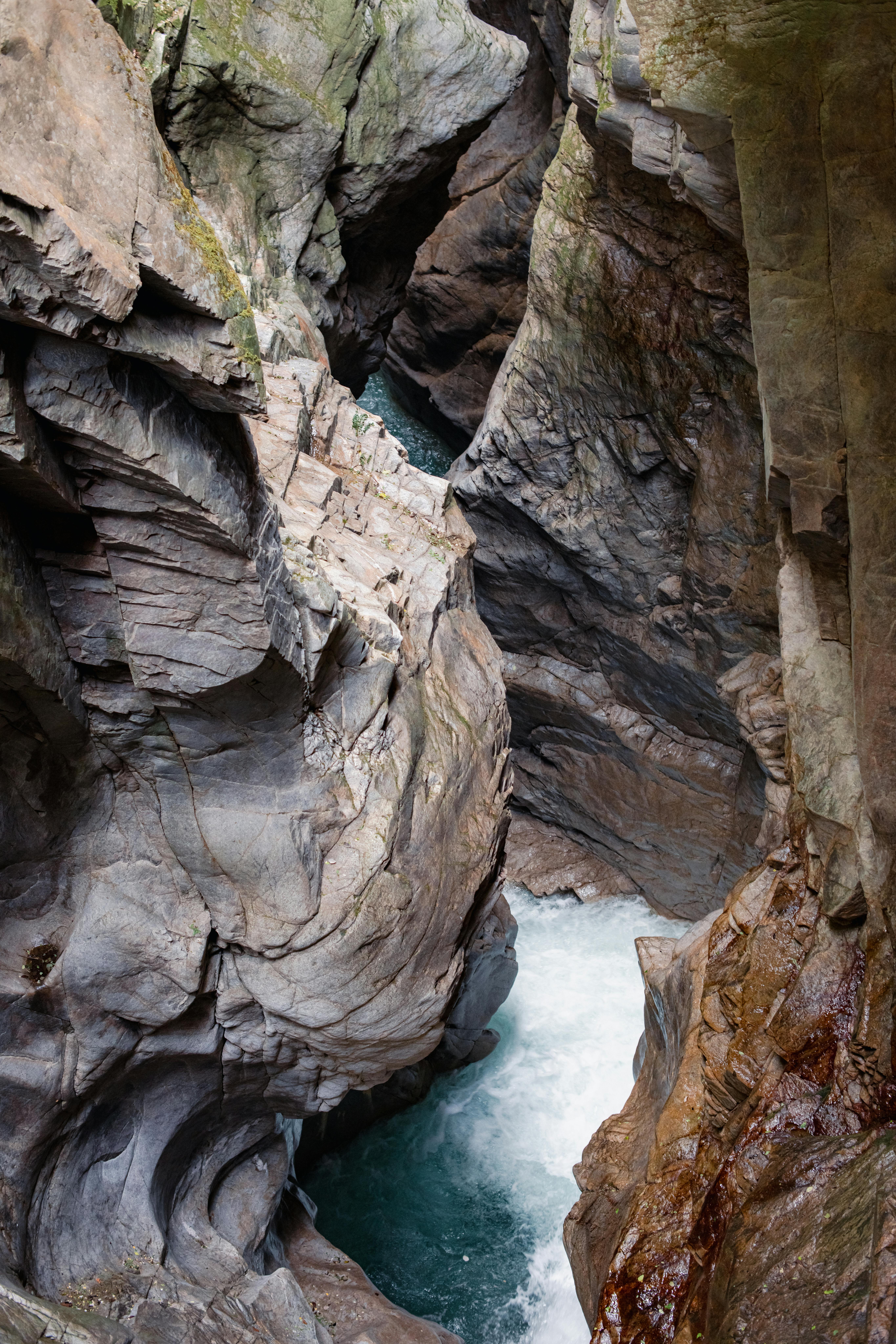 Dramatic view of a narrow gorge with turquoise waters in Italy's Alps.