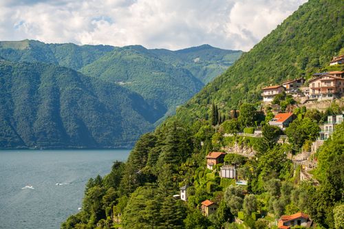 Free Breathtaking view of Lake Como, Italy, with lush green hills and picturesque villas under a vibrant summer sky. Stock Photo