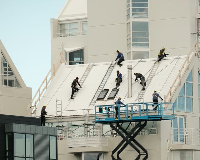 Modern roof repair Construction workers repairing a modern flat roof
