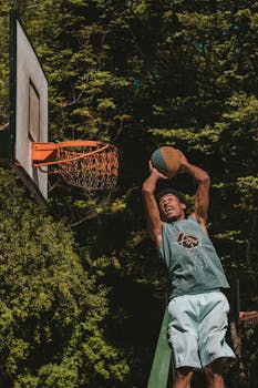 Athlete performing a dunk on an outdoor basketball court in Brazil.