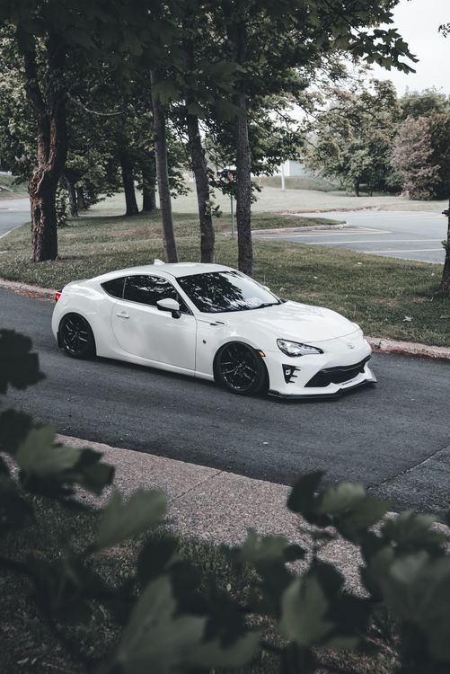Sleek White Sports Car on Scenic Road · Free Stock Photo