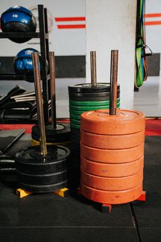 Stacked weight plates in varying colors at an indoor gym, ideal for strength training.