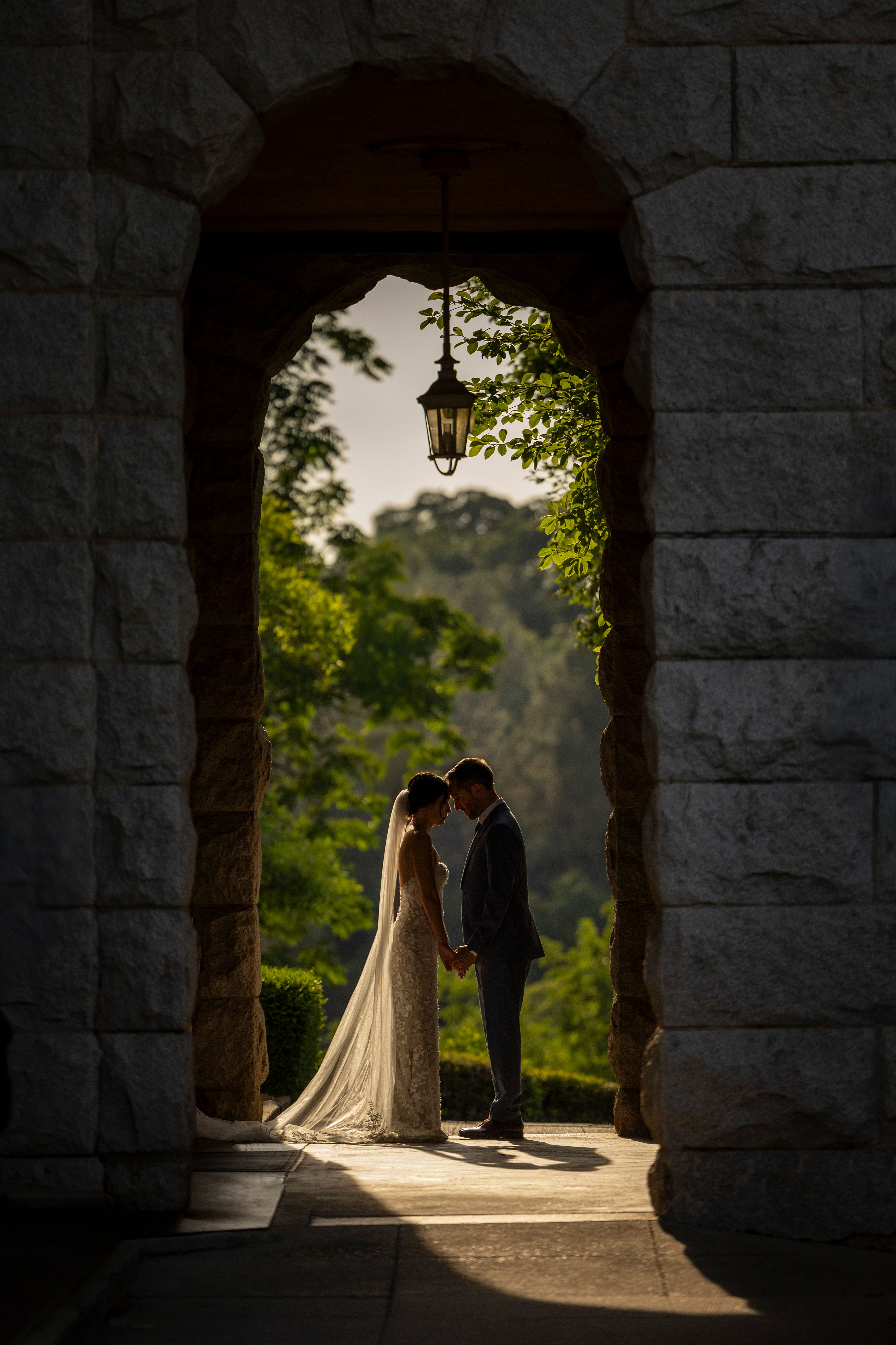 Romantic Wedding Couple Under Stone Archway · Free Stock Photo