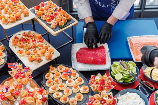 Elegant seafood platter with fresh salmon and sushi preparation at a culinary event.