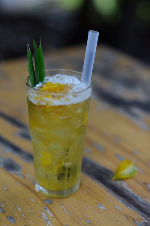 Free Chilled tropical iced tea in a glass with ice, garnished with pineapple and leaves, perfect for summer. Stock Photo
