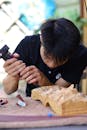 Artisan Carving Intricate Wooden Sculpture Outdoors