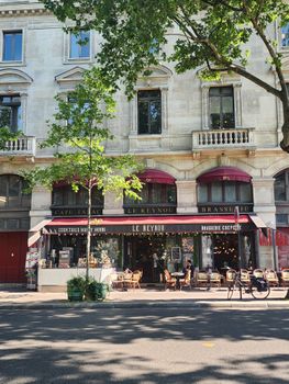 Le Reynou cafe with outdoor seating in Paris on a sunny day, showcasing French charm.