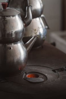 A vintage metal teapot steaming on a rustic stove in Seydişehir, Türkiye.