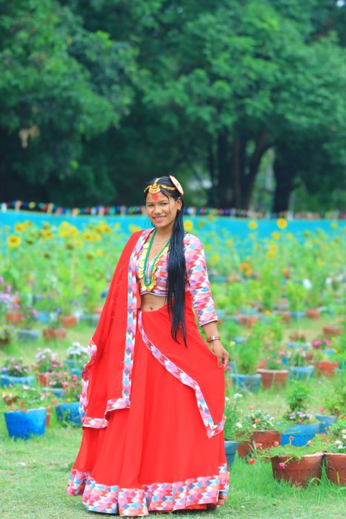 Free Woman in vibrant traditional Indian dress posing in a lush garden. Stock Photo