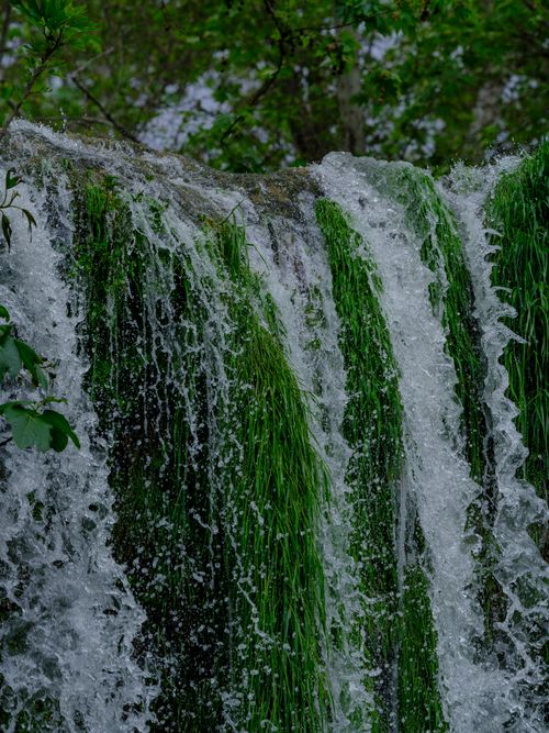 Free A beautiful waterfall with vibrant green moss and rocks, creating a refreshing natural scene. Stock Photo